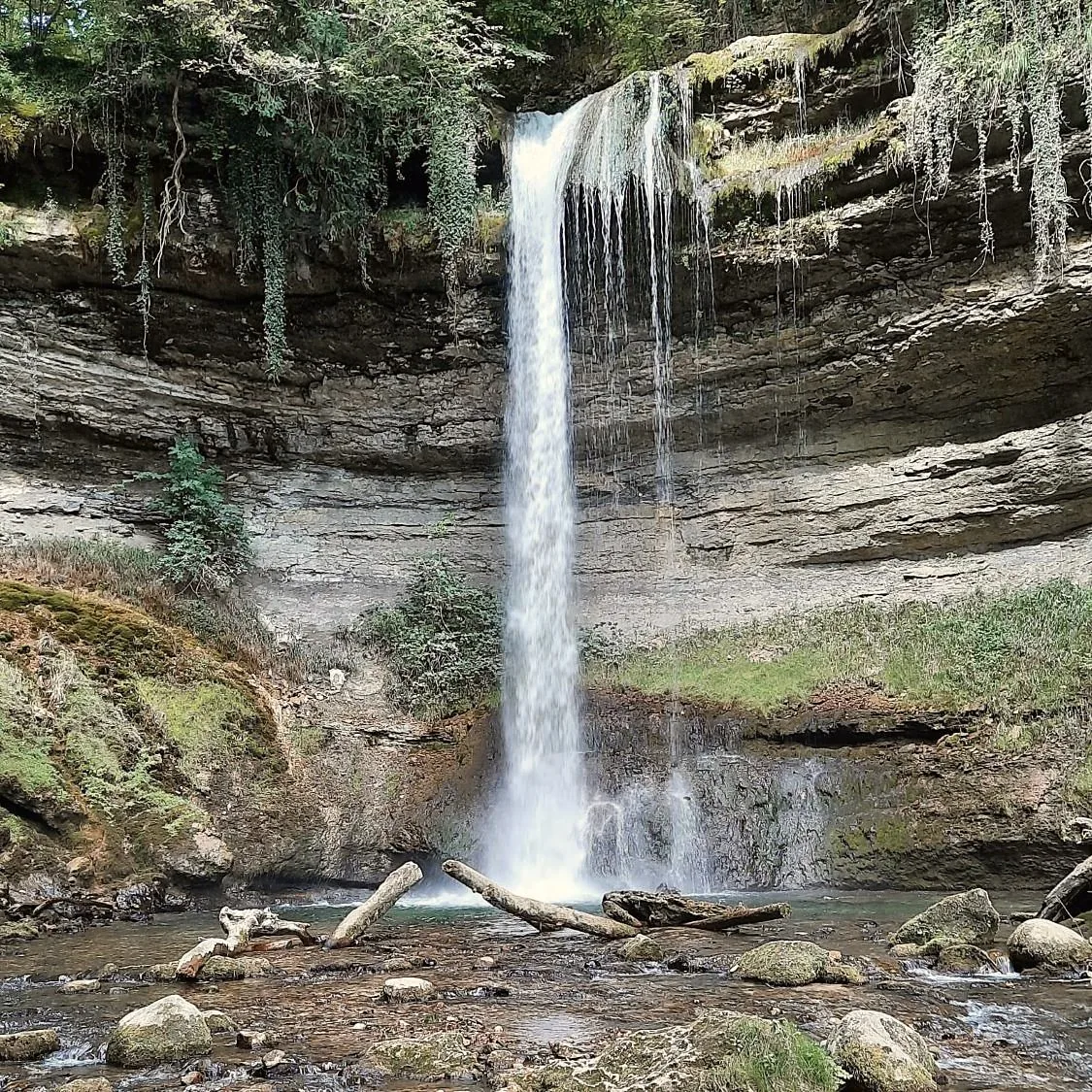 Cascade dans une gorge du Jura, entre falaises calcaires et végétation